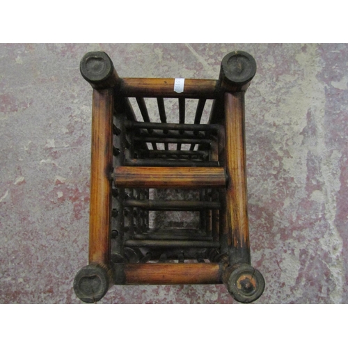 2585 - A Chinese wine rack to hold ten bottles and a red lacquered three tier container