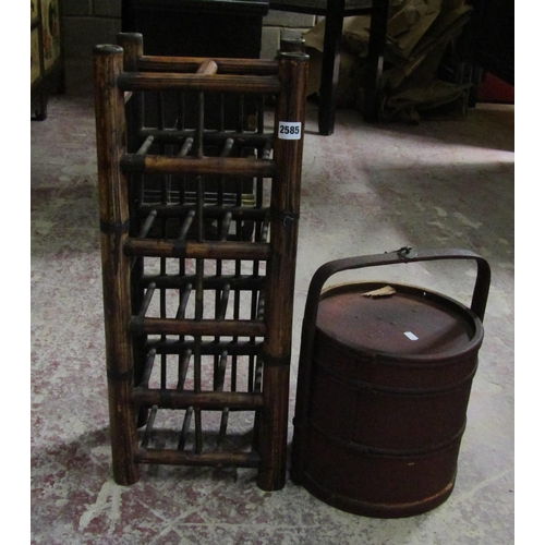 2585 - A Chinese wine rack to hold ten bottles and a red lacquered three tier container