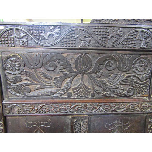 2699 - A 17th century and later box settle, with carved floral and fruiting vine detail, the crest dated 16... 