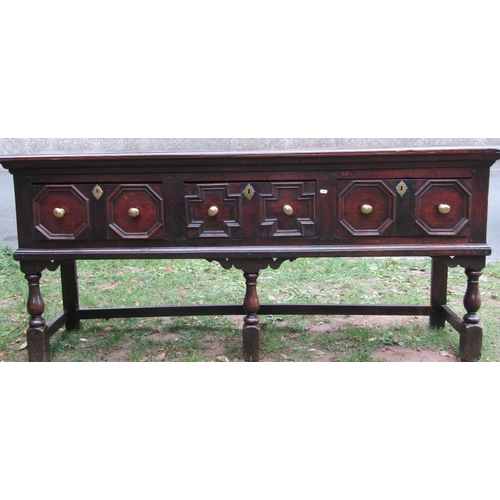 2718 - A 17th century oak dresser base with three drawers over geometric moulded detail, on three turned fo... 