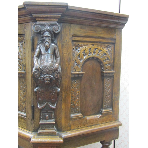 2727 - An Elizabethan style oak side cupboard, the central door flanked by two carved figures with open fra... 