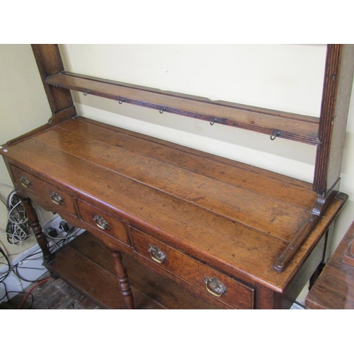 2759 - A small Georgian oak cottage pot board dresser, with three frieze drawers, the plate rack with three... 