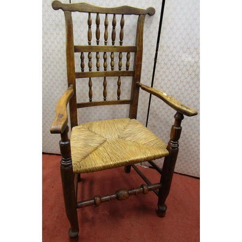 2767 - A Georgian ashwood spindle back elbow chair with rush seat on turned supports