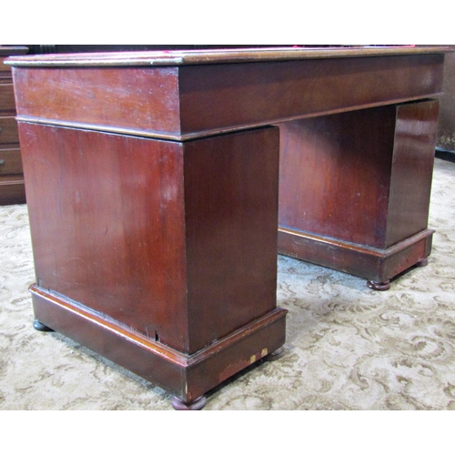 2332 - A Victorian mahogany kneehole twin pedestal writing desk fitted with the usual arrangement of nine f... 