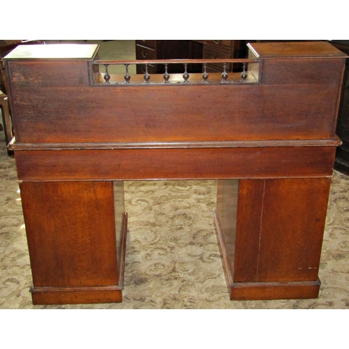 2338 - A Victorian oak kneehole twin pedestal desk fitted with nine graduated frieze drawers beneath an ins... 