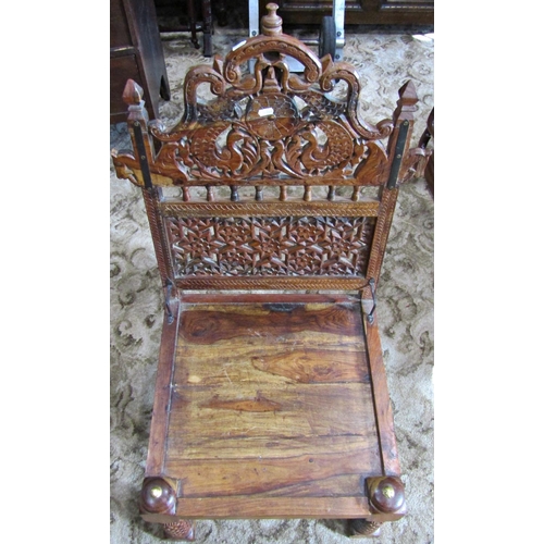 2341 - A low Indian hardwood chair with solid seat and decorative pierced back with repeating geometric, fl... 