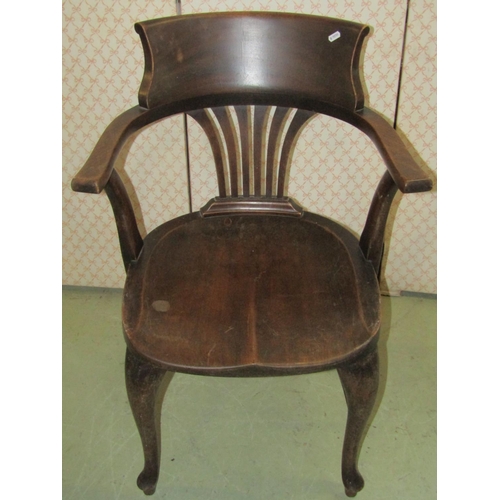 2355 - An early 20th century walnut office desk chair with combed splat over a saddle shaped seat