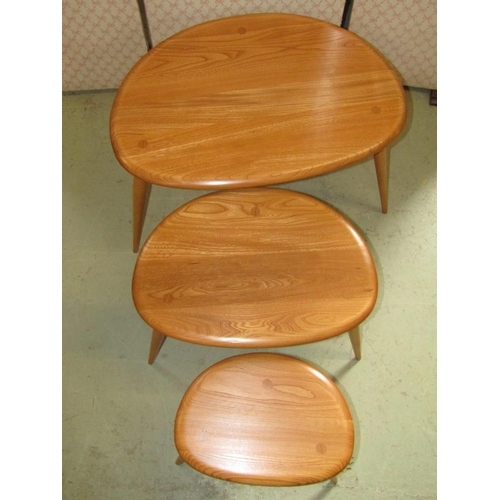 2391 - A nest of three Ercol light elm and beechwood 'Pebble' occasional tables