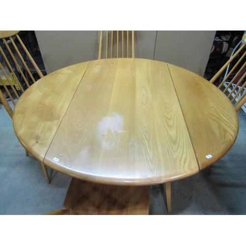 2393 - A vintage Ercol light elm and beechwood oval drop leaf dining table, raised on square tapered and sp... 