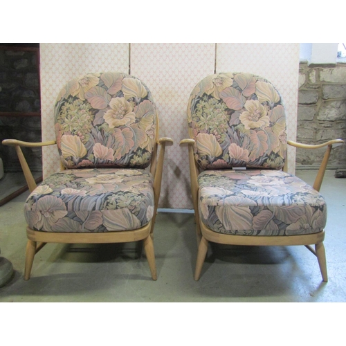 2397 - A pair of vintage Ercol light beechwood Windsor style hoop and stick back low deep seated arm chairs... 