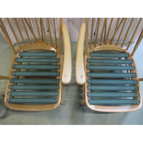 2397 - A pair of vintage Ercol light beechwood Windsor style hoop and stick back low deep seated arm chairs... 