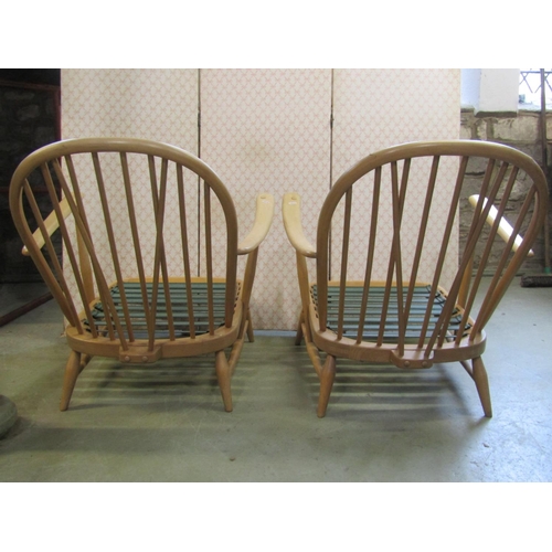 2397 - A pair of vintage Ercol light beechwood Windsor style hoop and stick back low deep seated arm chairs... 