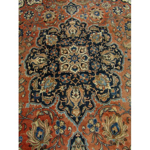 2526 - A large Malayer carpet, faded, with a central medallion with an overall floral pattern on pink groun... 