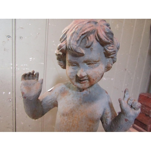 2091 - A vintage cast iron garden ornament in the form of a standing nude cherub with wavy hair and hands a... 