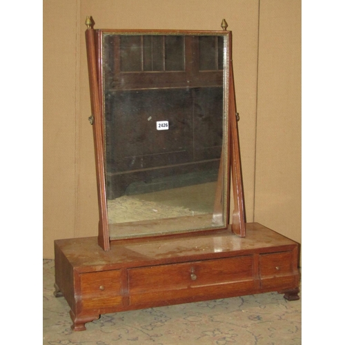 2426 - A Georgian oak toilet mirror of rectangular form raised on a box base with three frieze drawers 62 c... 