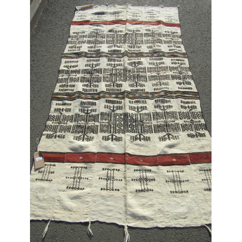 2501 - A West-African blanket with an intricate design of black line work on a natural wool ground, made-up... 