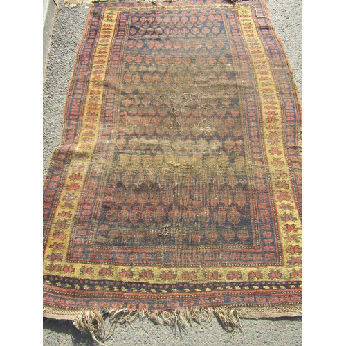 2509 - Three worn Middle Eastern rugs, all wool on wool with central repeated designs in magenta, iron-red,... 