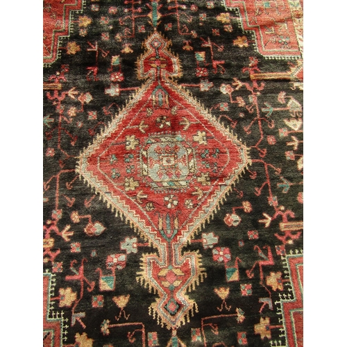 2531 - A North West Persian Nahawand rug with lozenge pole medallion and flower and branch motifs on a char... 