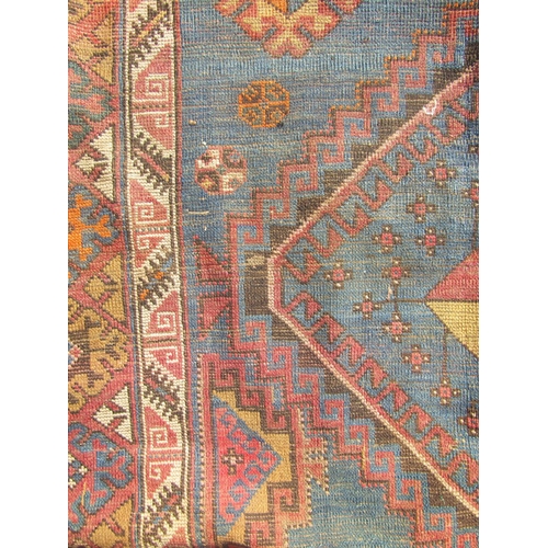 2532 - A Middle Eastern low-pile rug with two diamond medallions on a cobalt ground and a border of lobed a... 