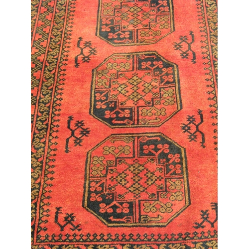 2536 - An Afghan Turkoman rug with large elephant foot design in varying orange, brown and blue/black tones... 