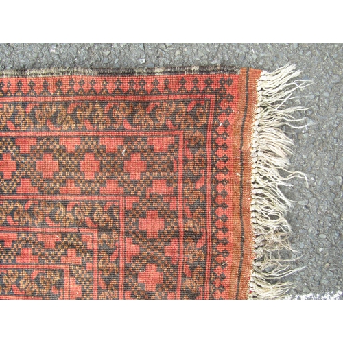 2536 - An Afghan Turkoman rug with large elephant foot design in varying orange, brown and blue/black tones... 