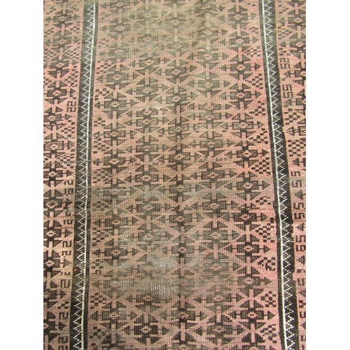 2537 - A worn Middle Eastern rug with repeated geometric design throughout in pale maroon and brown tones, ... 