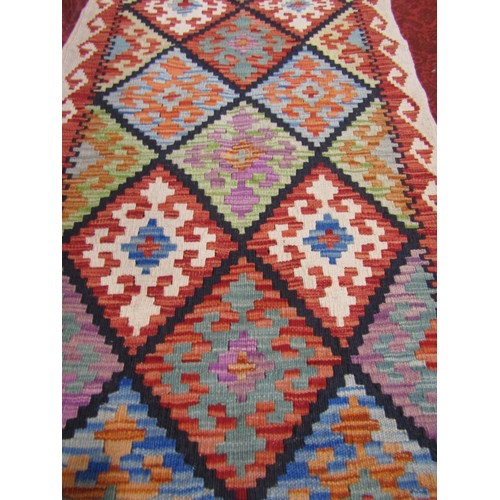 2542 - A Chobi Kilim Runner with geometric burdock diamond design and hooked border in multicoloured tones,... 