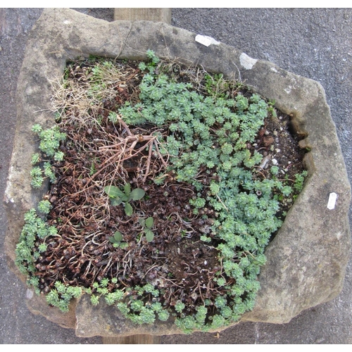 2065 - A weathered irregular shaped rough-hewn natural stone trough approx 60 cm wide x 55 cm deep x 20 cm ... 