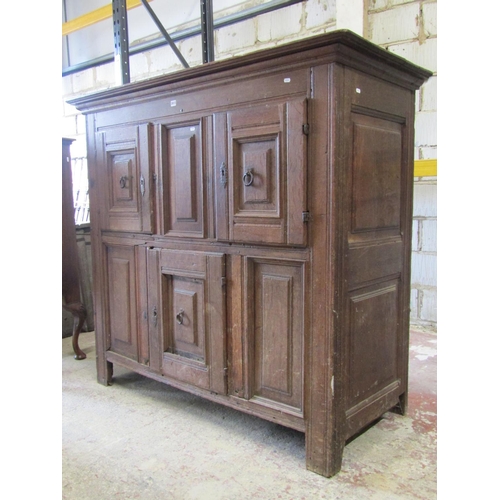 2613 - A 18th century oak cupboard enclosed by three panelled doors and further panels, with steel fittings... 