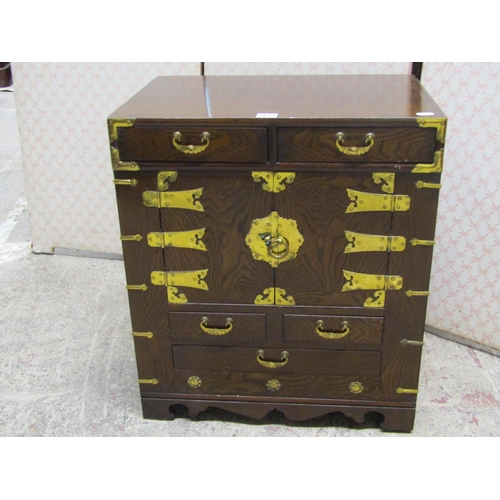 2617 - A small Korean cabinet in oak enclosed by two doors and an arrangement of five drawers with brass fi... 