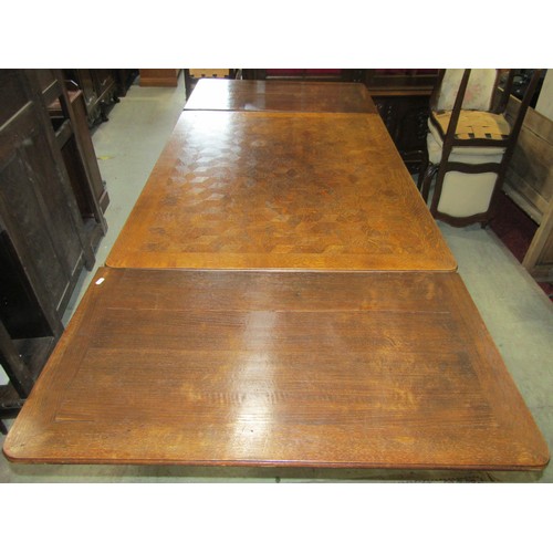 2437 - A continental oak draw leaf dining table with cube marquetry top, together with a set of eight (6&2)... 