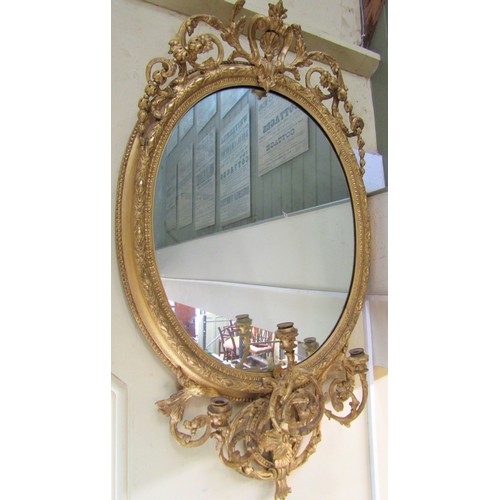 2662a - An early 19th century gilt framed wall mirror of oval form, the decorative gilt frame with repeating... 