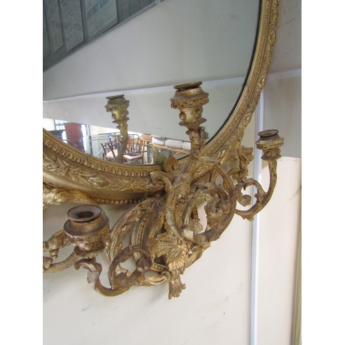 2662a - An early 19th century gilt framed wall mirror of oval form, the decorative gilt frame with repeating... 