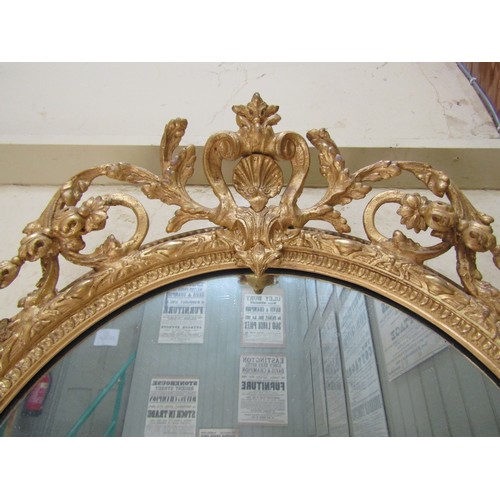 2662a - An early 19th century gilt framed wall mirror of oval form, the decorative gilt frame with repeating... 