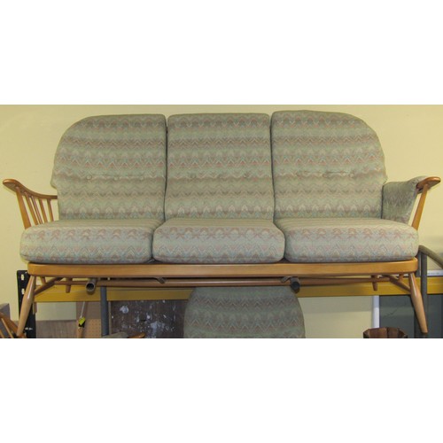 2645 - A light Ercol three seat stick-back sofa with two matching armchairs and a stool (4)