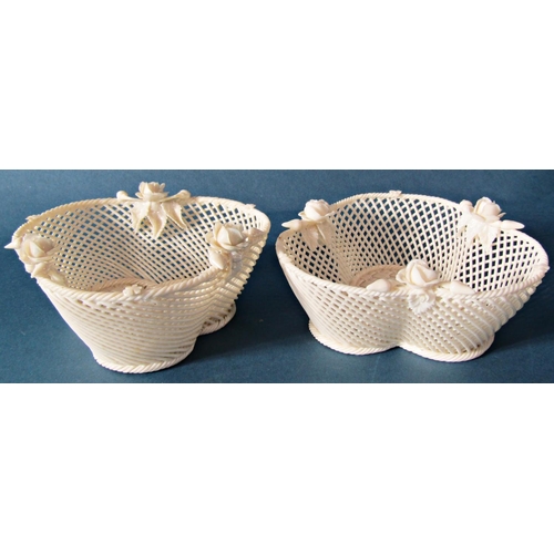 1027 - A pair of Belleek lattice work trefoil shaped baskets, the bases with woven detail, encrusted with r... 