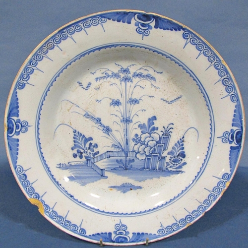 1054 - A late 18th century blue and white tin glazed plate with chinoiserie garden detail within a repeatin... 