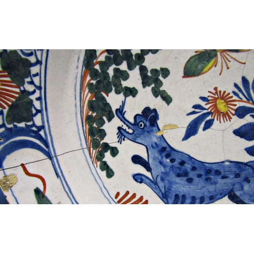 1054 - A late 18th century blue and white tin glazed plate with chinoiserie garden detail within a repeatin... 