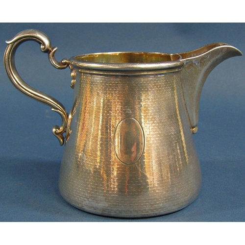 1207 - A silver Garrard & Co milk jug with a scrolled handle, London 1910, 9.2 oz