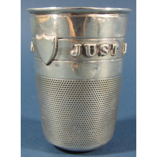 1261 - A late Victorian novelty silver stirrup cup in the form of a thimble bearing the inscription 'Just a... 