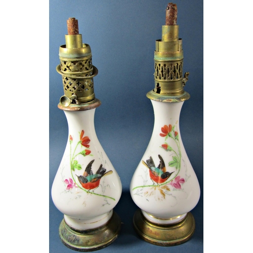 1138 - A pair oil lamps with decoratively painted glass bodies with colourful birds amongst flowers, five s... 