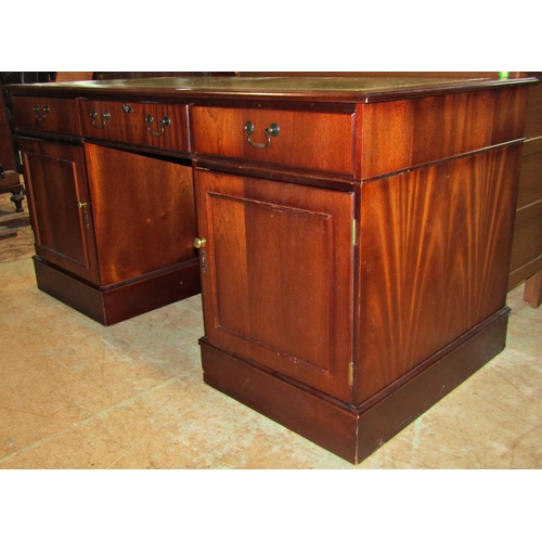 2193 - An office desk in the Georgian style with inset leather top over an arrangement of cupboards and dra... 