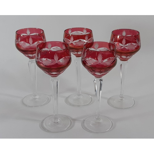 1133a - Five ruby cased wine glasses on a facetted stems and circular foot, 20cm tall.