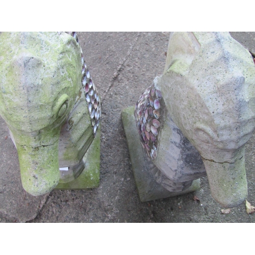 2005 - A pair of weathered cast composition stone garden ornaments in the form of sea horses with coloured ... 