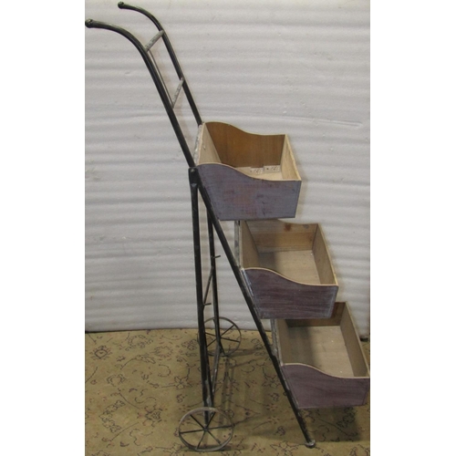 2124 - A two wheeled tubular steel framed and folding display stand supporting three ply wood trays 46 cm w... 