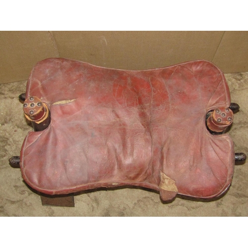 2188 - A vintage camel stool with leather pad seat (af)