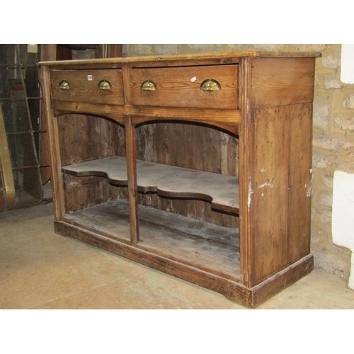 2190 - A rustic stripped pine kitchen dresser base fitted with two frieze drawers over an open shaped shelf... 