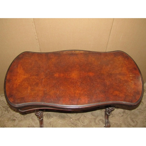 2197 - A walnut and figured walnut veneered fold over top card table with serpentine outline, raised on tur... 