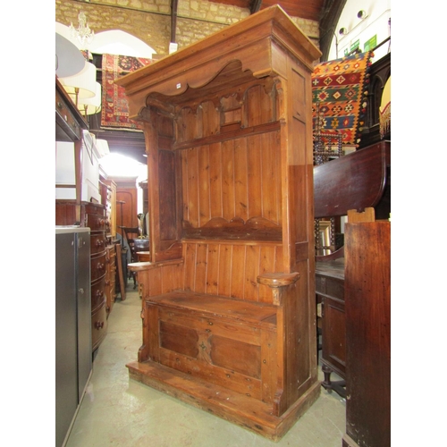 2273 - A substantial reclaimed pine settle with panelled framework, hinged box seat, shaped canopy and carv... 