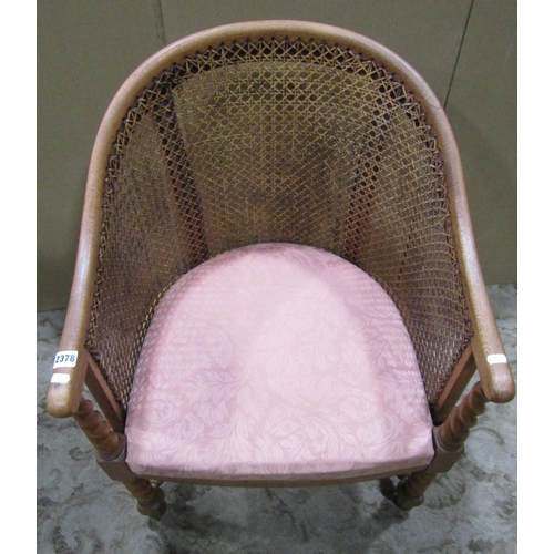 2378 - A 1920s bergere tub chair with stained beechwood frame raised on barley twist supports